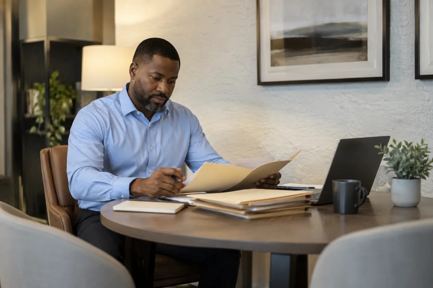 Illustrative scene: Insurance operations professional reviewing anonymous folders at a meeting table