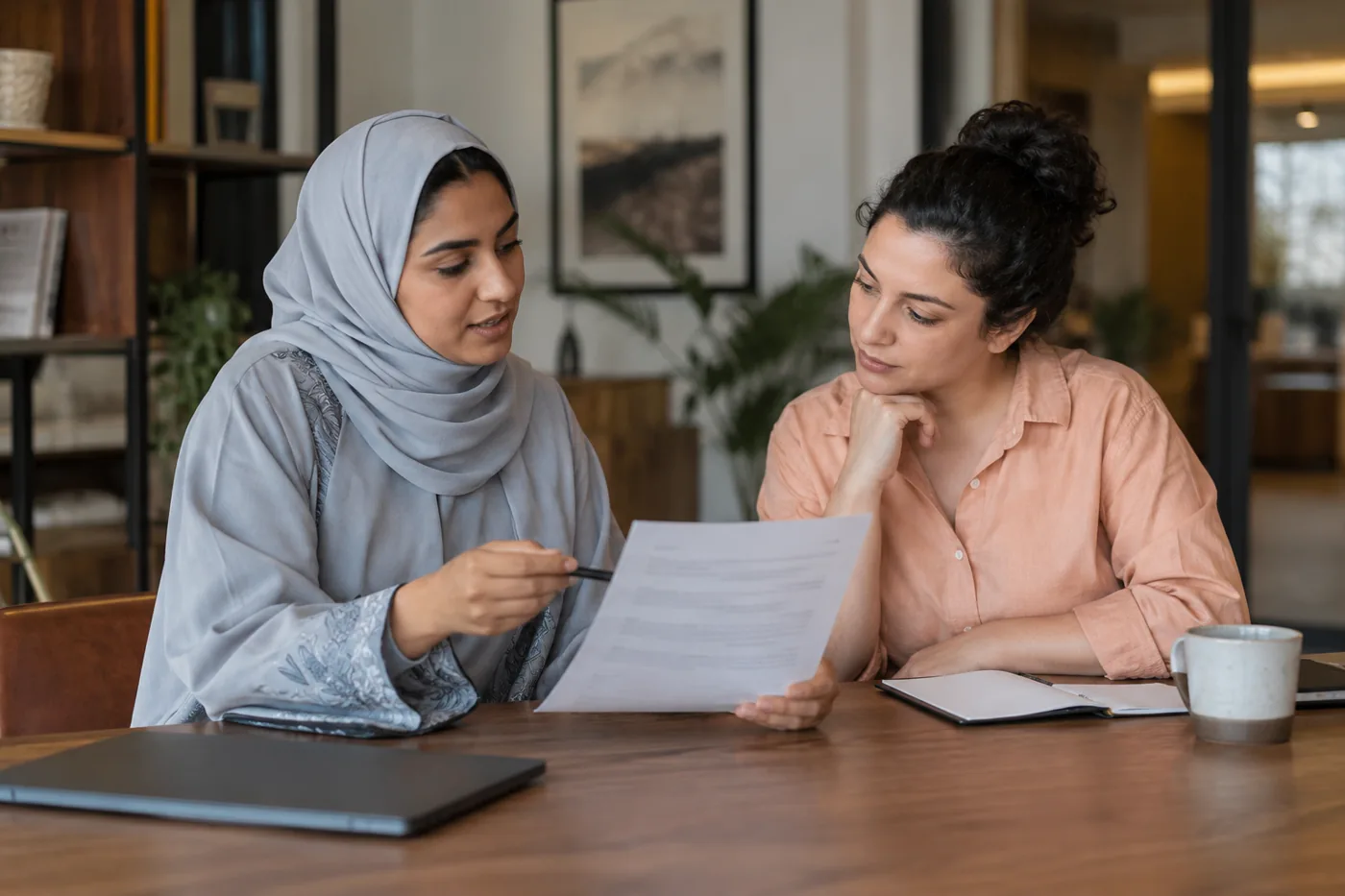 Illustrative scene: Colleagues discussing a printed monitoring notice at a meeting bench